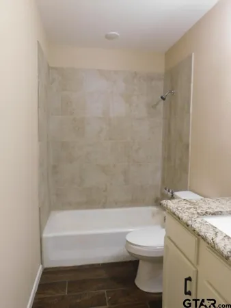 a bathroom with a granite countertop bathtub toilet and a sink