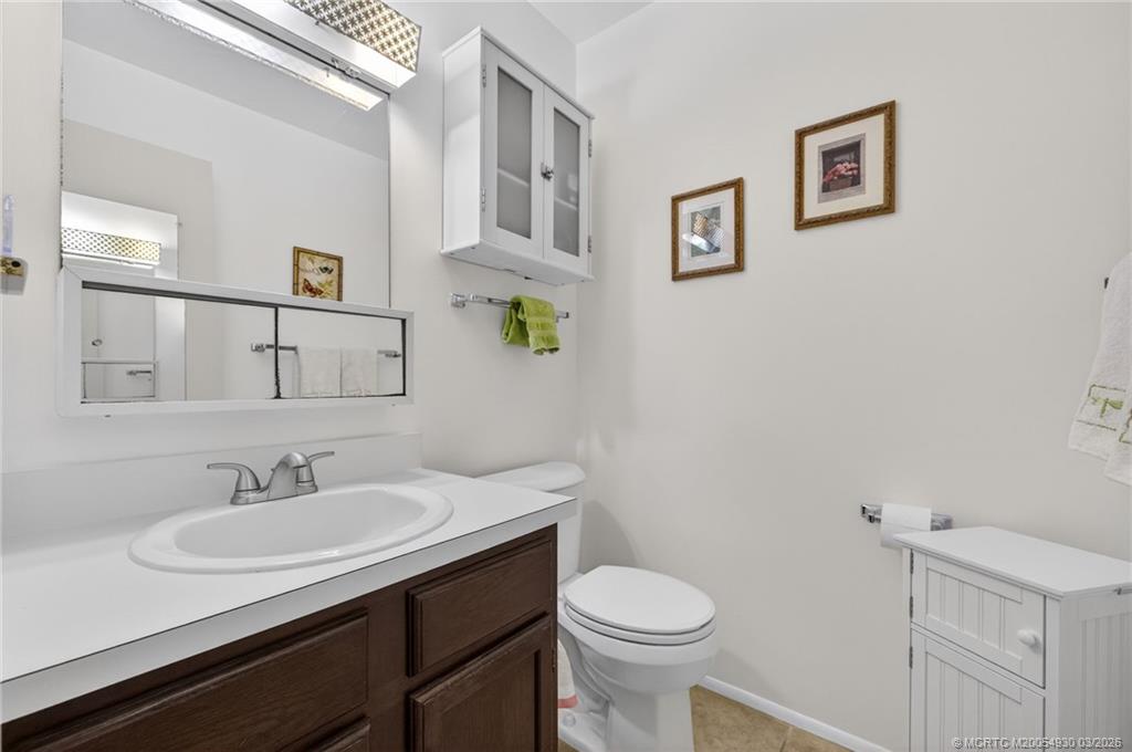 1225 Northwest 21st Street, Unit 1810 Stuart, FL 34994 - Photo 13 of 48 a bathroom with a sink vanity and a toilet