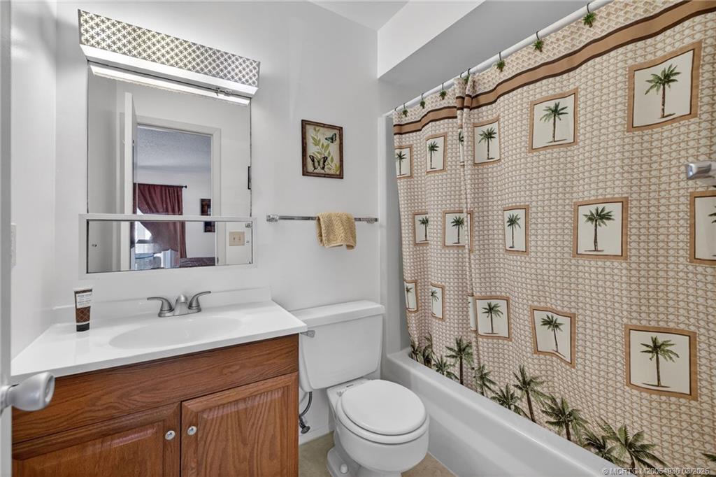 1225 Northwest 21st Street, Unit 1810 Stuart, FL 34994 - Photo 16 of 48 a bathroom with a sink a toilet a mirror and shower