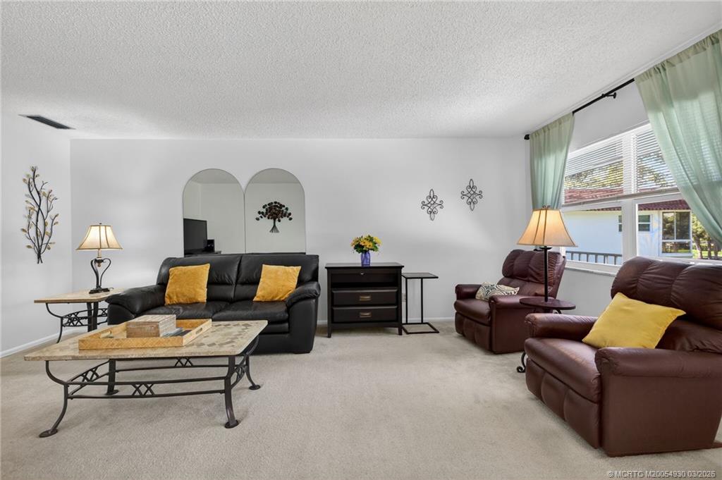 1225 Northwest 21st Street, Unit 1810 Stuart, FL 34994 - Photo 3 of 48 a living room with furniture a window and a lamp