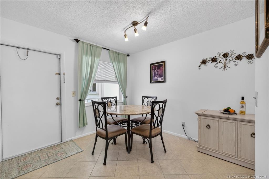 1225 Northwest 21st Street, Unit 1810 Stuart, FL 34994 - Photo 6 of 48 a view of a dining room with furniture and a chandelier fan