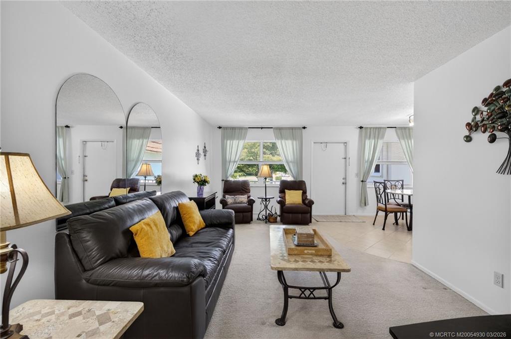 1225 Northwest 21st Street, Unit 1810 Stuart, FL 34994 - Photo 8 of 48 a living room with furniture and a potted plant