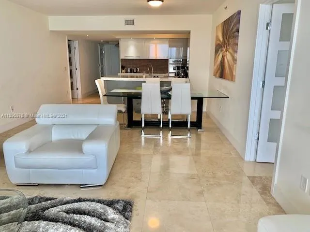 a living room with furniture and a dining table