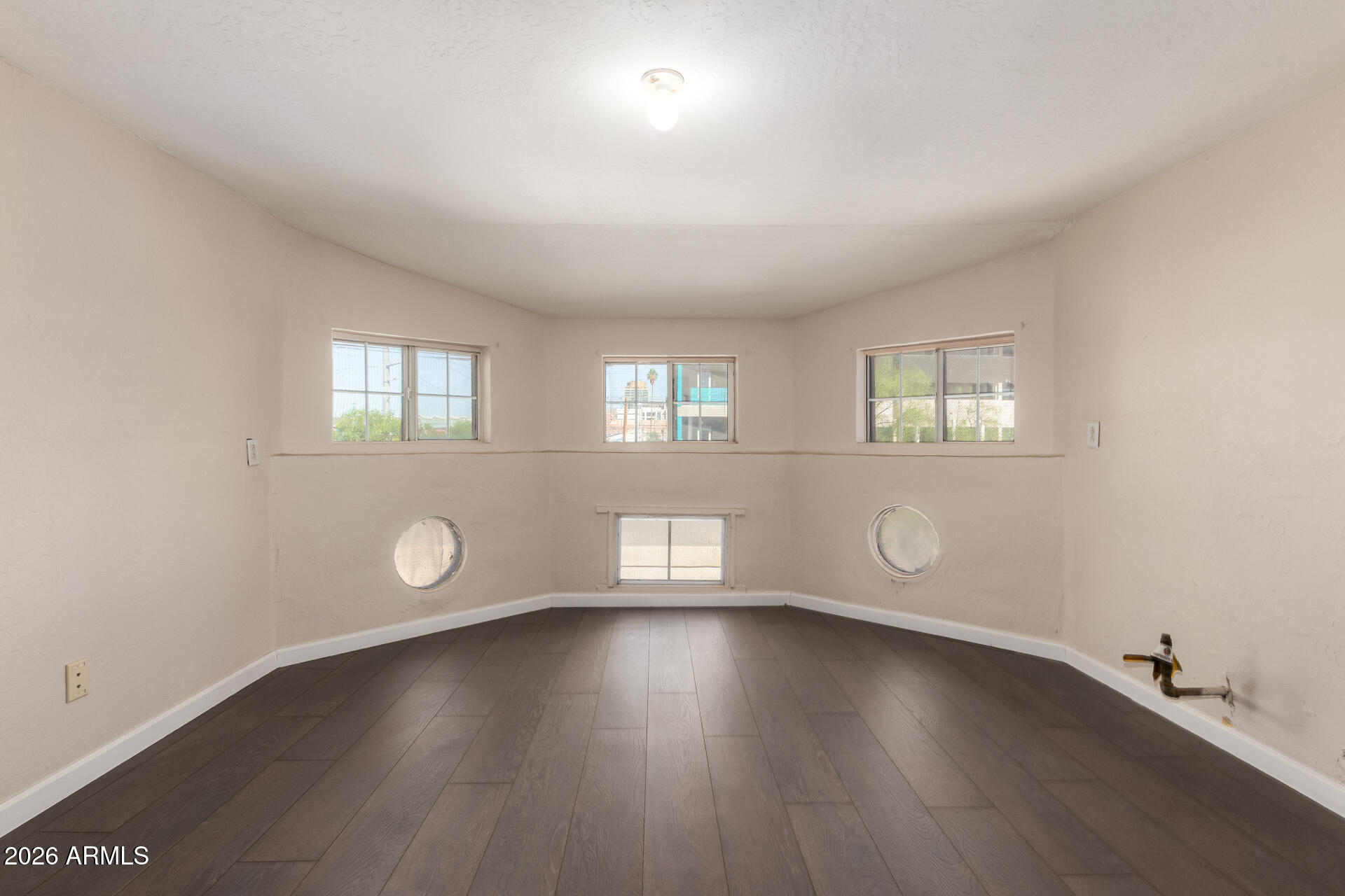 819 South 3rd Avenue Phoenix, AZ 85003 - Photo 32 of 45 an empty room with wooden floor and windows