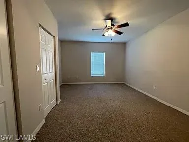 a view of an empty room with a chandelier fan