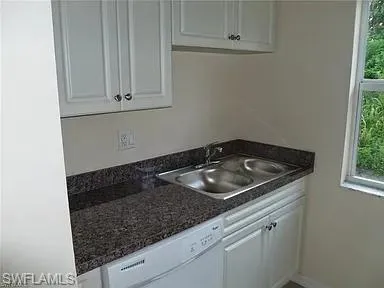 a close view of a sink a stove and microwave in a kitchen