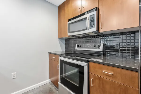 a kitchen with granite countertop cabinets stove and microwave