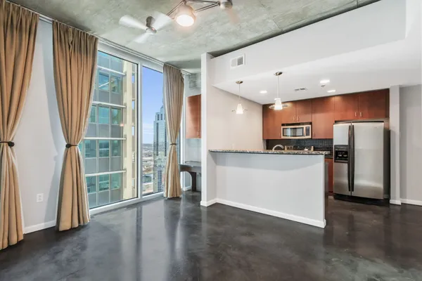 a view of kitchen with stainless steel appliances granite countertop a refrigerator and a sink