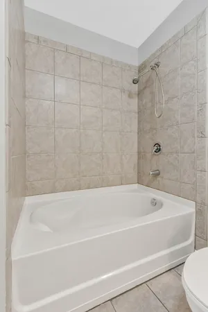 a bathroom with a granite countertop bathtub sink vanity mirror and toilet