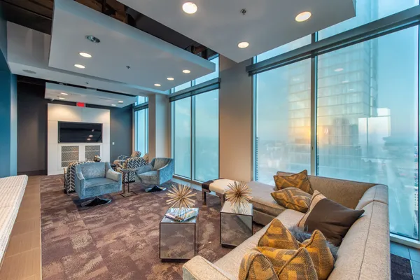 a living room with furniture kitchen view and a large window