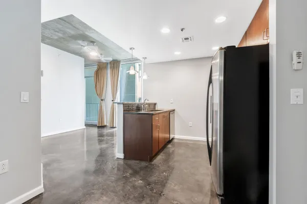 a view of a refrigerator in kitchen and a window
