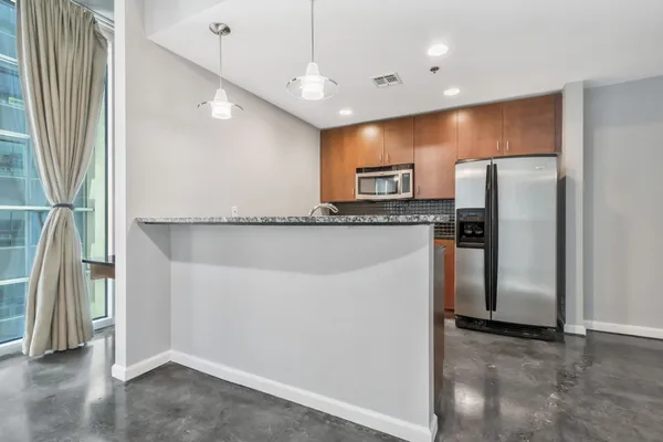 a kitchen with granite countertop a refrigerator a sink and a stove