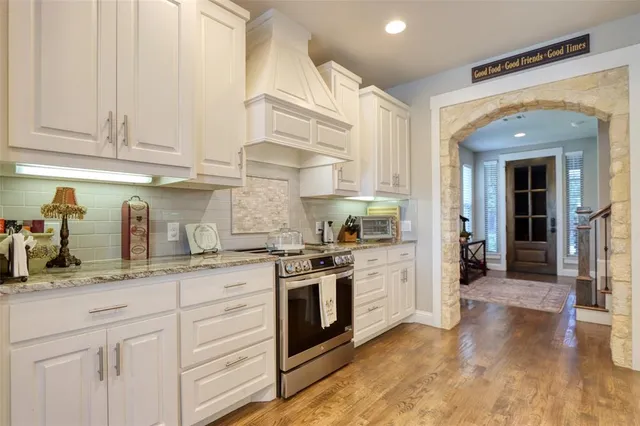 a kitchen with granite countertop white cabinets and white appliances