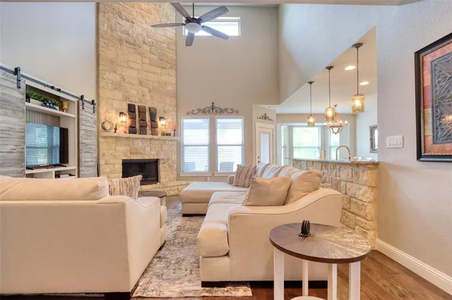 a living room with furniture a fireplace and a chandelier