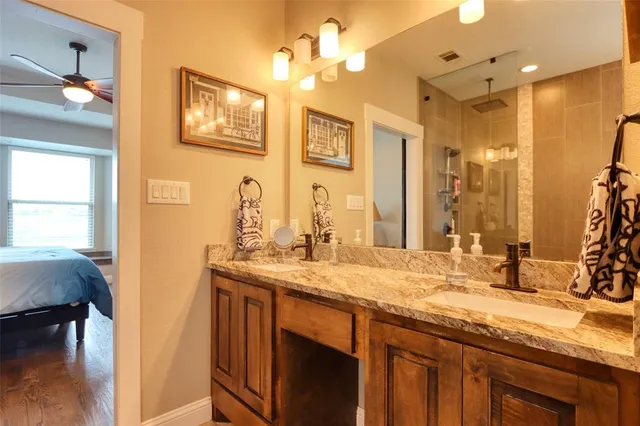 a bathroom with a granite countertop sink a large mirror and a shower