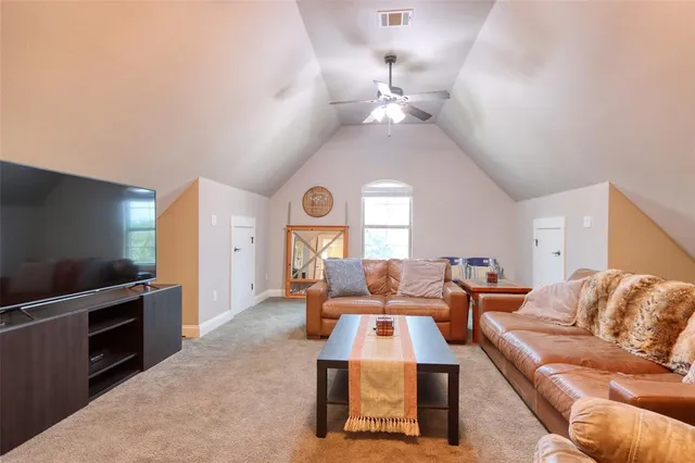 a living room with furniture a chandelier and a flat screen tv