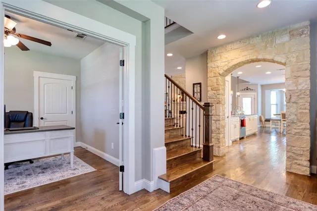 a view of a hallway with wooden floor and staircase