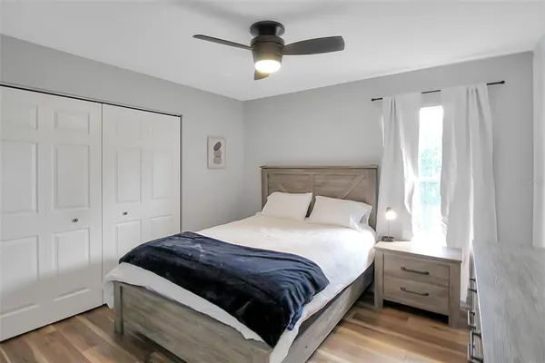 a bedroom with a bed and wooden floor