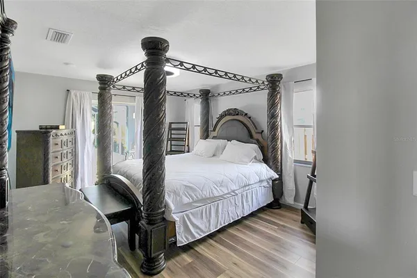 a bedroom with a bed and a large mirror