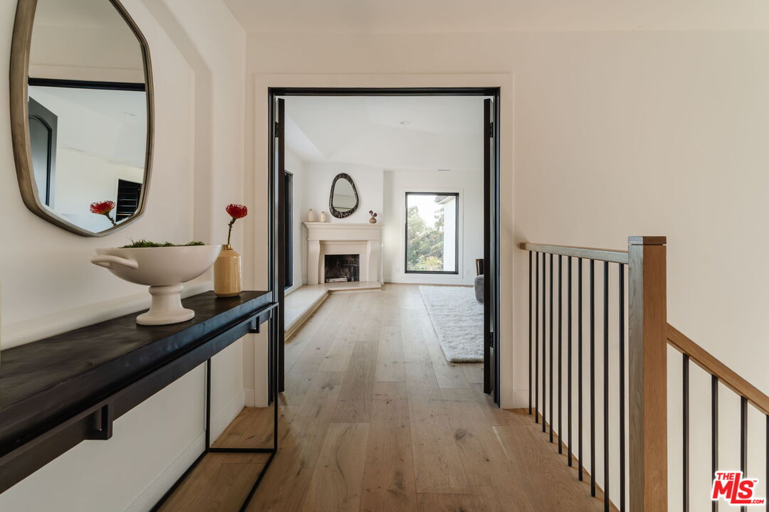 1666 Summitridge Drive Beverly Hills, CA 90210 - Photo 16 of 39 a view of a room with wooden floor and windows