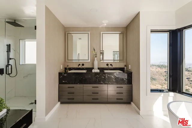 a bathroom with a granite countertop tub sink and mirror