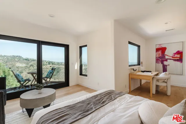 a bedroom with a bed and a large window