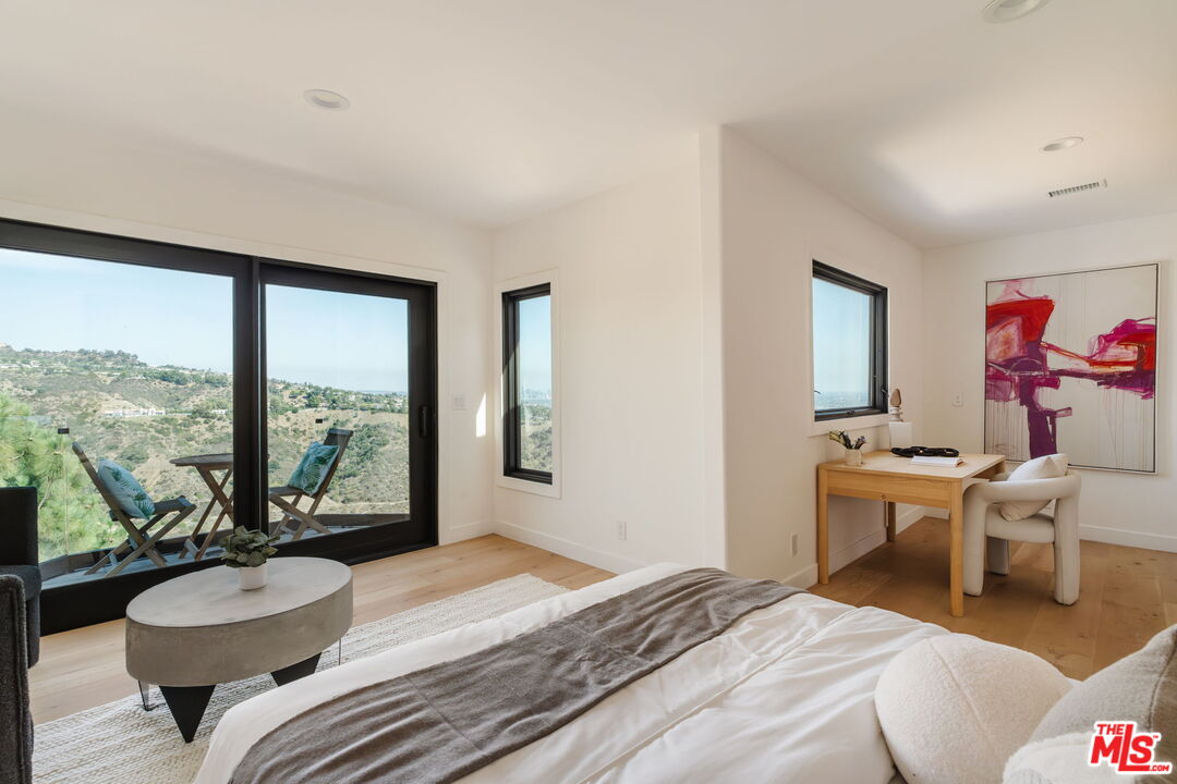 1666 Summitridge Drive Beverly Hills, CA 90210 - Photo 25 of 39 a bedroom with a bed and a large window