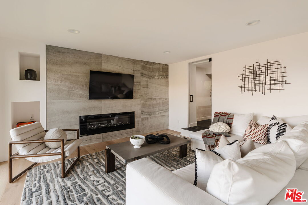 1666 Summitridge Drive Beverly Hills, CA 90210 - Photo 27 of 39 a living room with furniture and a flat screen tv