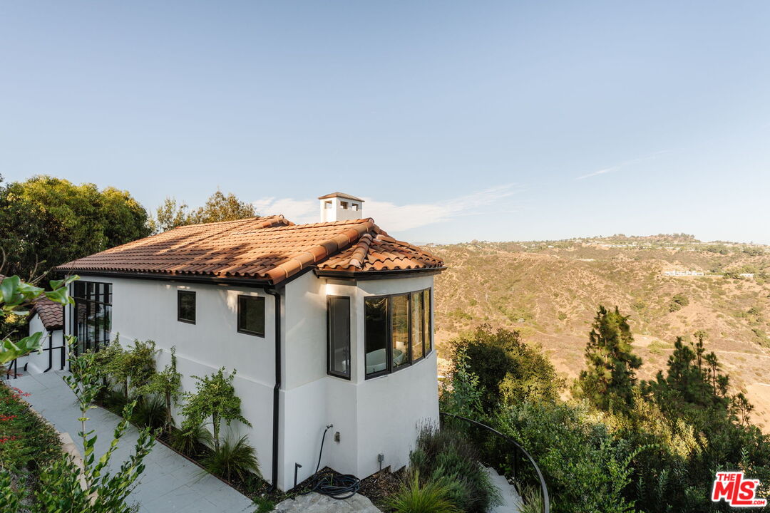 1666 Summitridge Drive Beverly Hills, CA 90210 - Photo 34 of 39 a white house with a big yard and plants