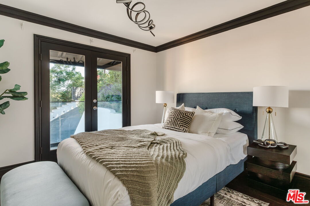 1666 Summitridge Drive Beverly Hills, CA 90210 - Photo 37 of 39 a bedroom with a bed and wooden floor