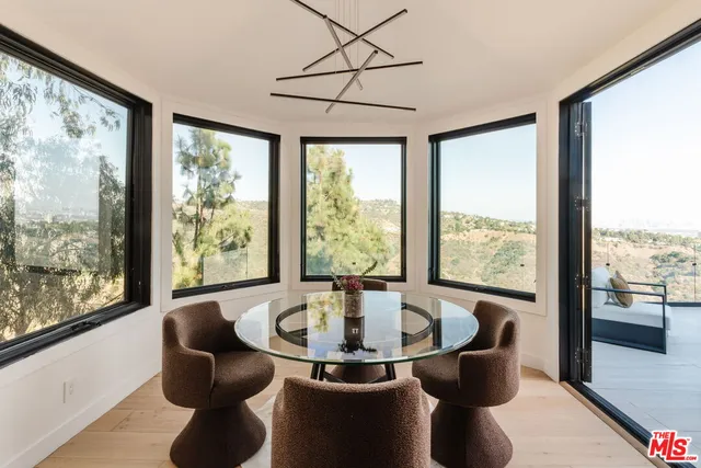 a dining room with large windows and wooden floor
