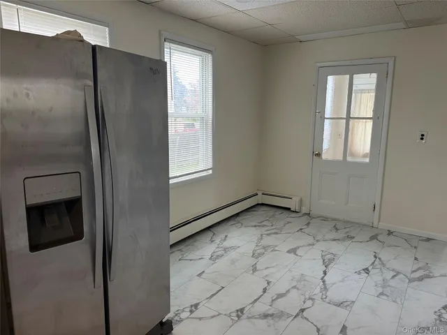 a view of an empty room with windows and closet
