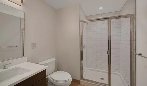 a bathroom with a sink a toilet and shower