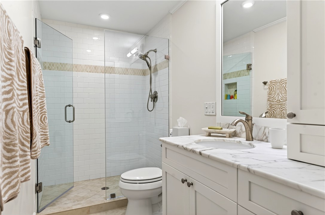 2743 Ocean Drive, Unit 50E Vero Beach, FL 32963 - Photo 24 of 36 a bathroom with a granite countertop sink a toilet and shower