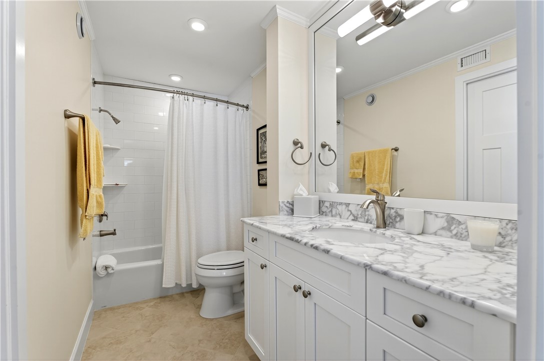 2743 Ocean Drive, Unit 50E Vero Beach, FL 32963 - Photo 27 of 36 a bathroom with a granite countertop sink a toilet a mirror and shower