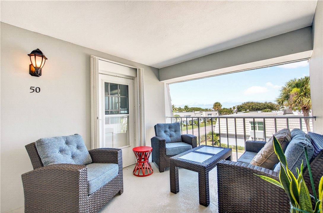 2743 Ocean Drive, Unit 50E Vero Beach, FL 32963 - Photo 6 of 36 a living room with furniture and a floor to ceiling window