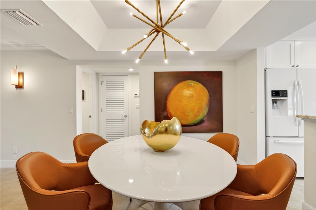 2743 Ocean Drive, Unit 50E Vero Beach, FL 32963 - Photo 10 of 36 a view of a dining room with furniture and chandelier