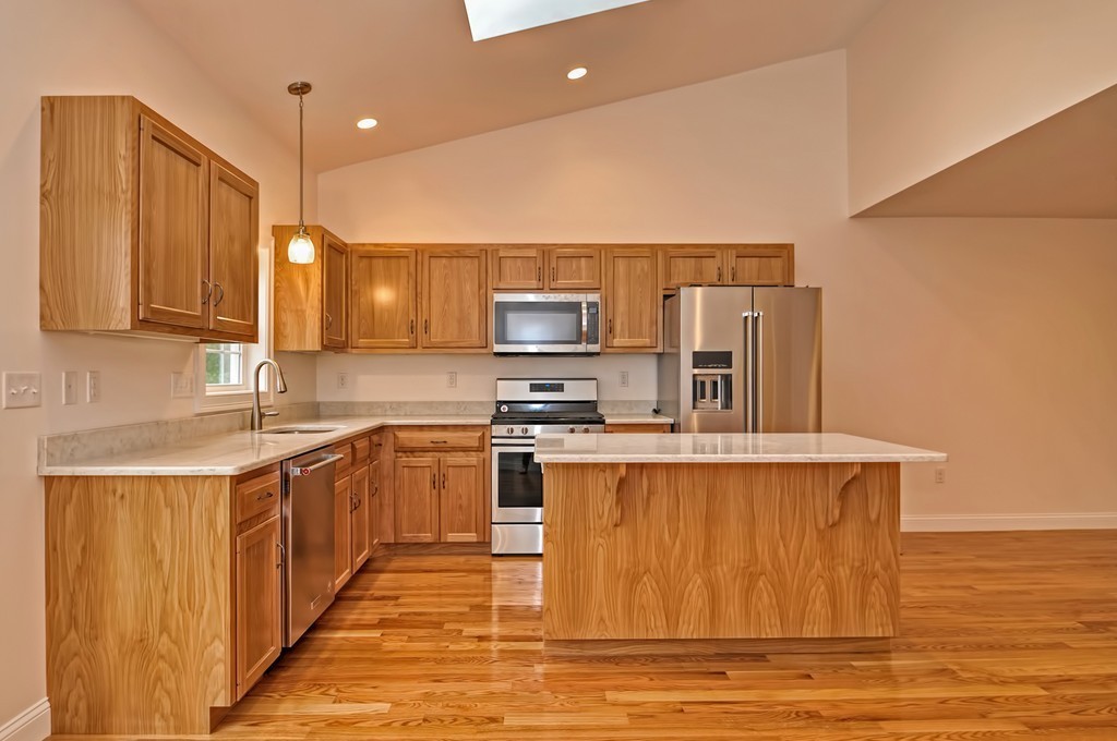 87 Ariel Circle Sutton, MA 01590 - Photo 16 of 30 a kitchen with stainless steel appliances granite countertop a sink and a stove top oven with wooden floor