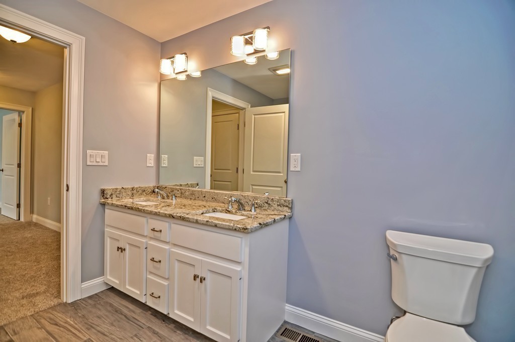 87 Ariel Circle Sutton, MA 01590 - Photo 23 of 30 a bathroom with a granite countertop toilet sink and mirror