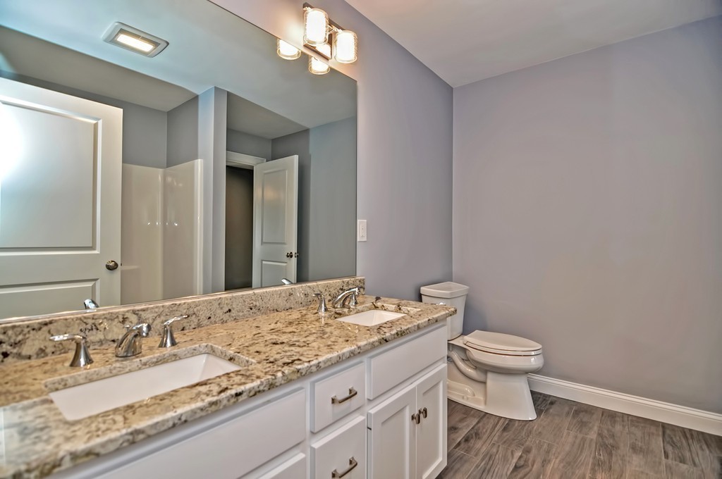 87 Ariel Circle Sutton, MA 01590 - Photo 24 of 30 a bathroom with a granite countertop sink a toilet and a mirror