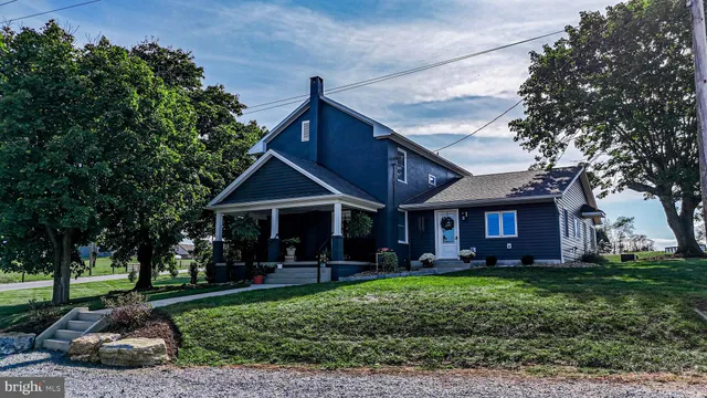 a view of a house with a big yard and a large tree