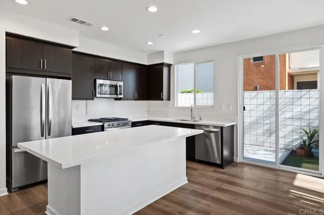 a kitchen with stainless steel appliances a sink stove and refrigerator