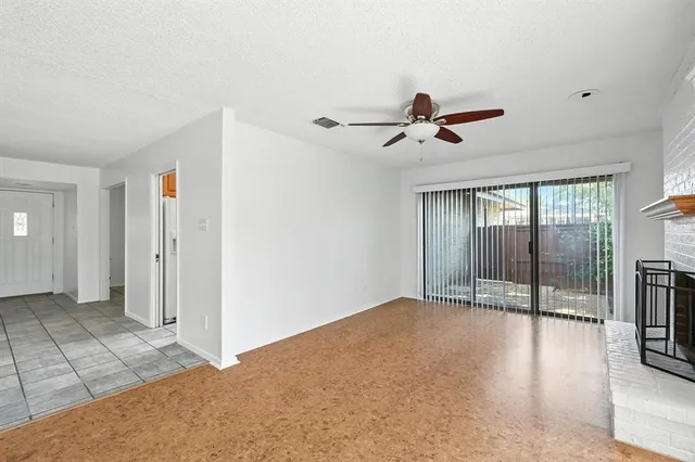 a view of a livingroom with a ceiling fan and window