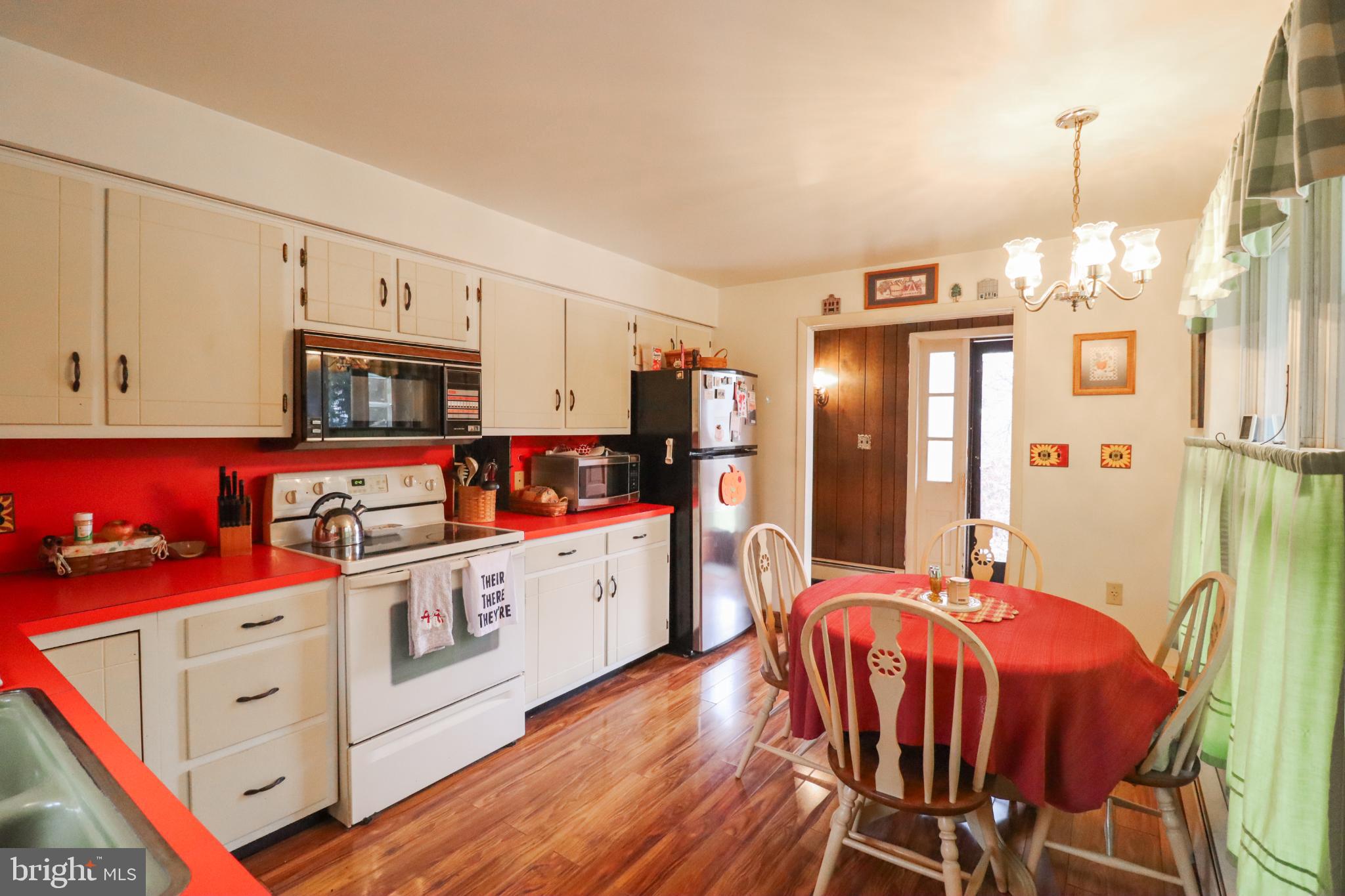 81 Rupp Road Gettysburg, PA 17325 - Photo 9 of 53 a kitchen with stainless steel appliances kitchen island granite countertop a refrigerator a stove a sink dishwasher and white cabinets with wooden floor