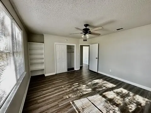 a view of a hallway with wooden floor and closet