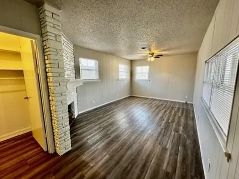a view of an empty room with chandelier fan and a fireplace