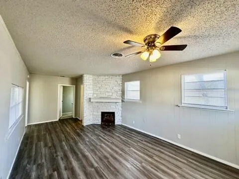 a view of empty room with wooden floor and fireplace