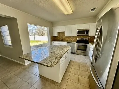 a spacious bathroom with a granite countertop sink and a mirror