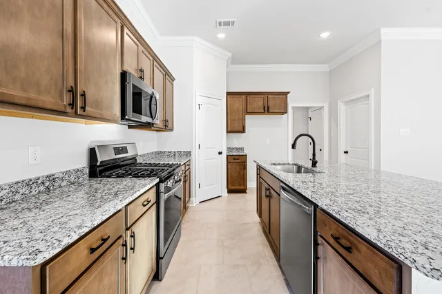 a kitchen with stainless steel appliances granite countertop a sink stove and cabinets