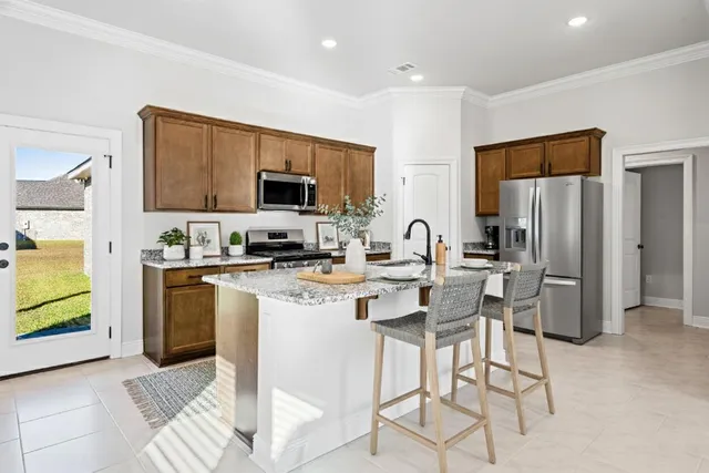 a kitchen with stainless steel appliances granite countertop a refrigerator and a stove top oven